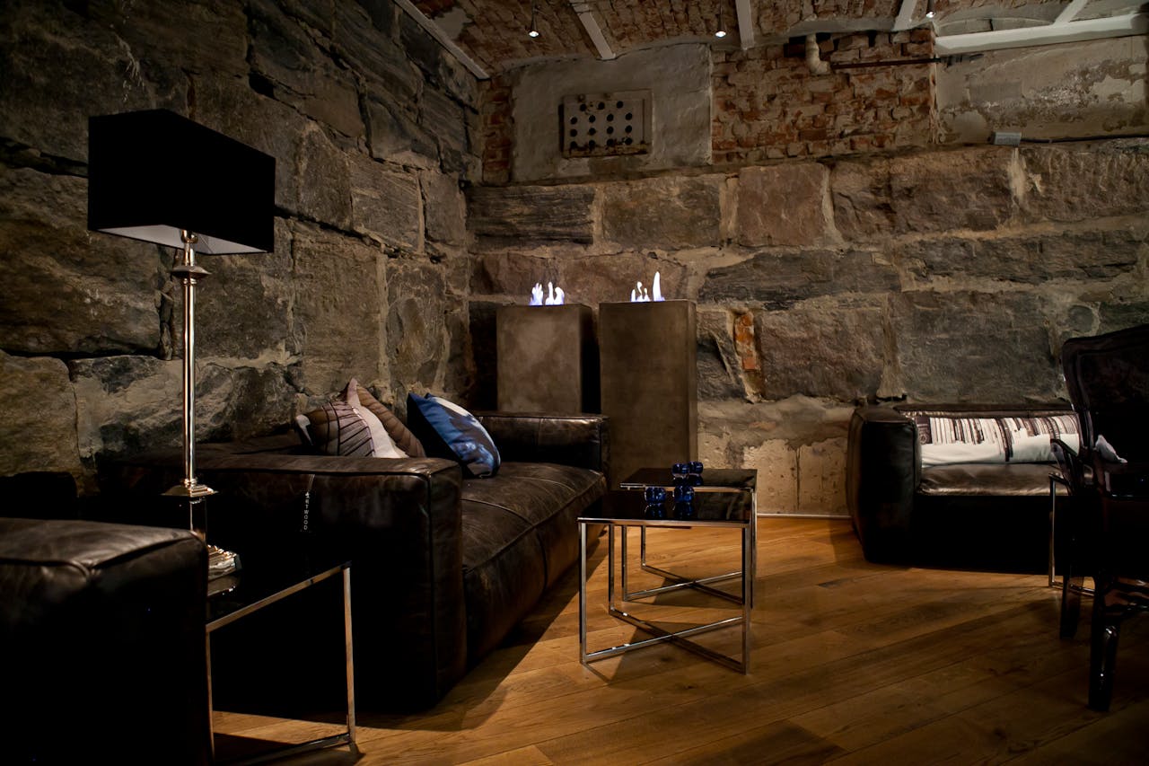 services-04 Elegant living room featuring rustic stone walls and modern furniture design.